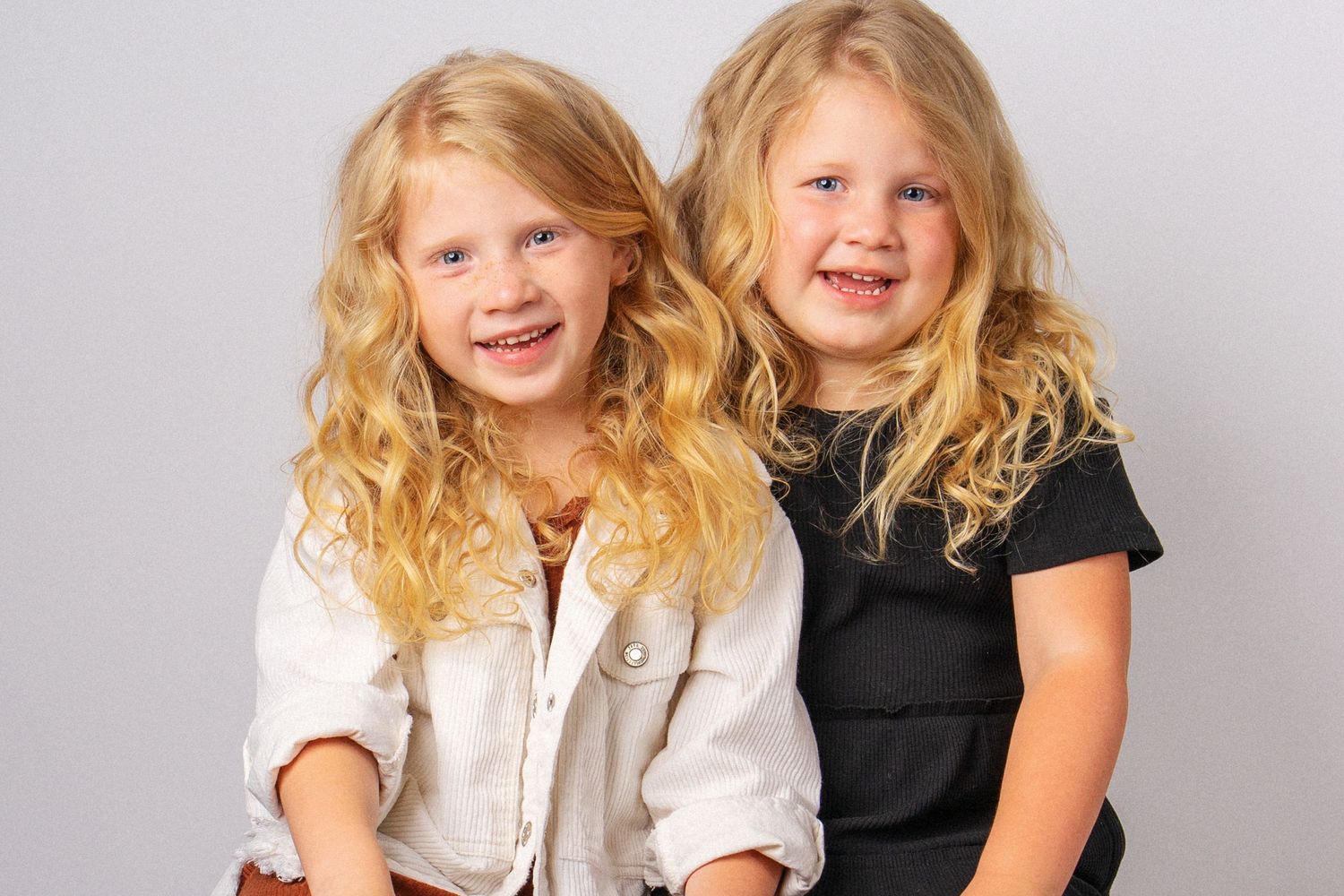 Little girls sitting on a stool in Dandridge, TN photography studio for sister's portrait session.