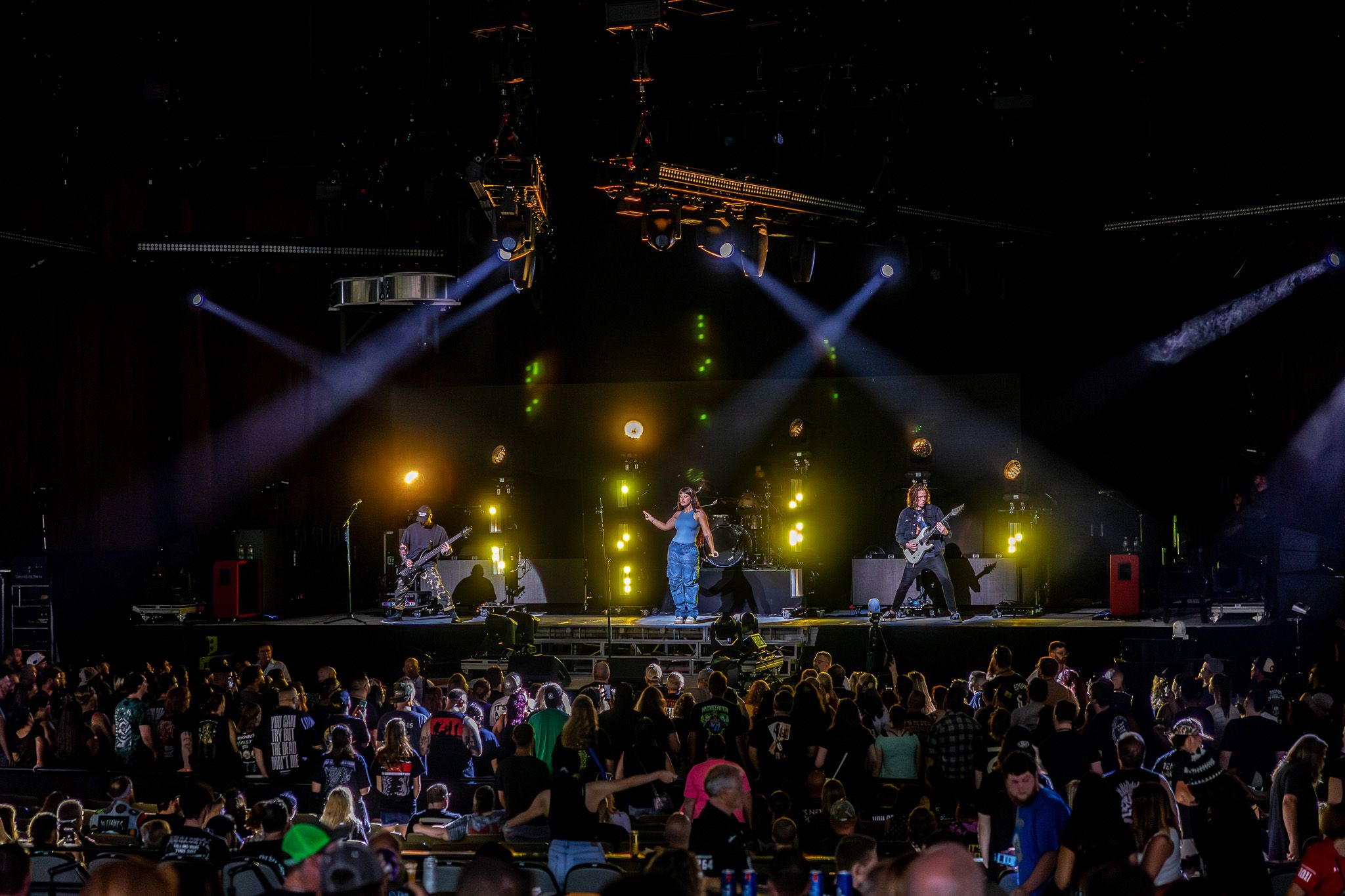 Wide concert shot showing band performing on illuminated stage with crowd below.