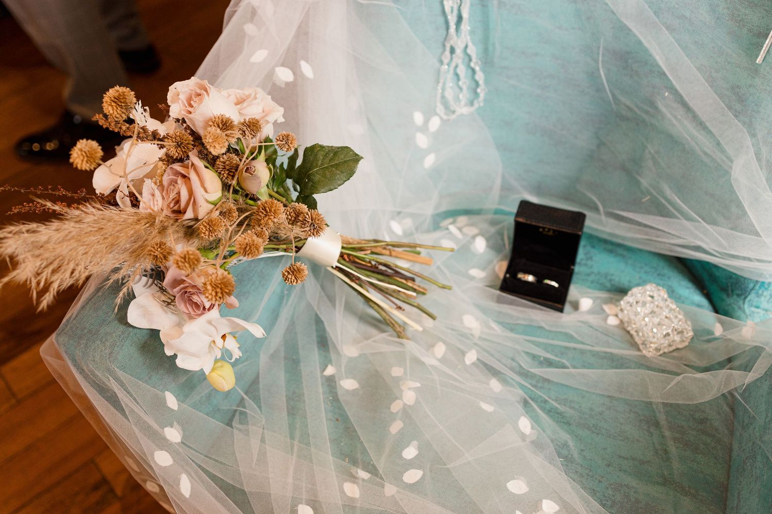 Wedding details featuring delicate veils and floral arrangements in soft turquoise tones.
