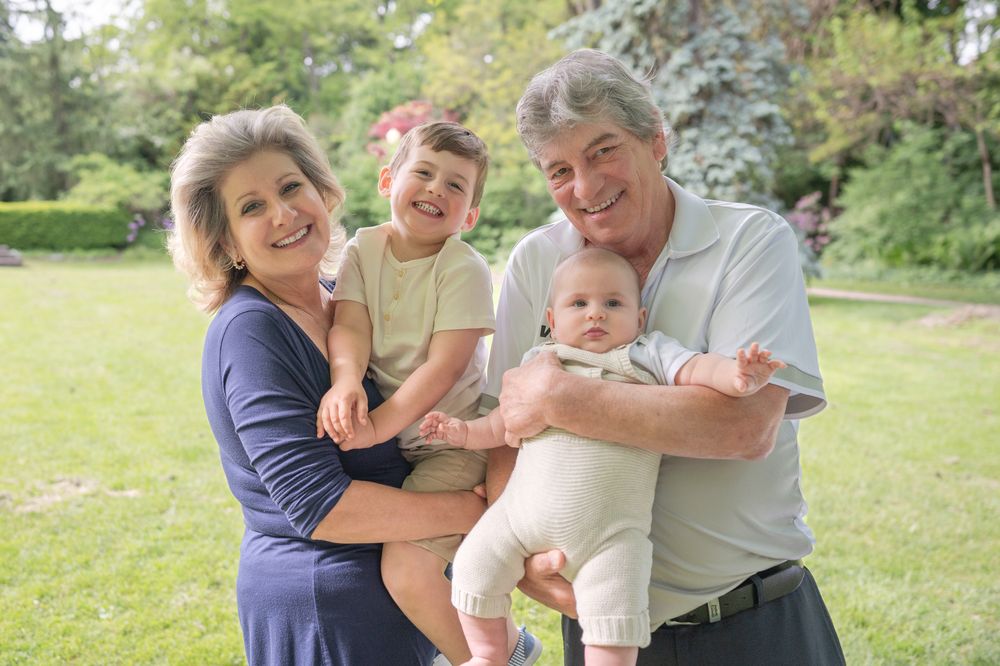 A family enjoys quality time together outdoors on a sunny day in a lush garden setting.