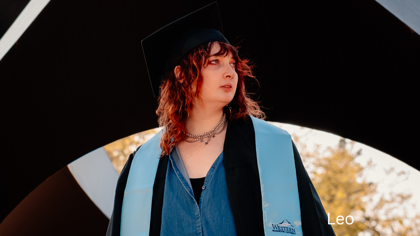 Graduate wearing black cap and light blue stole framed through circular archway.