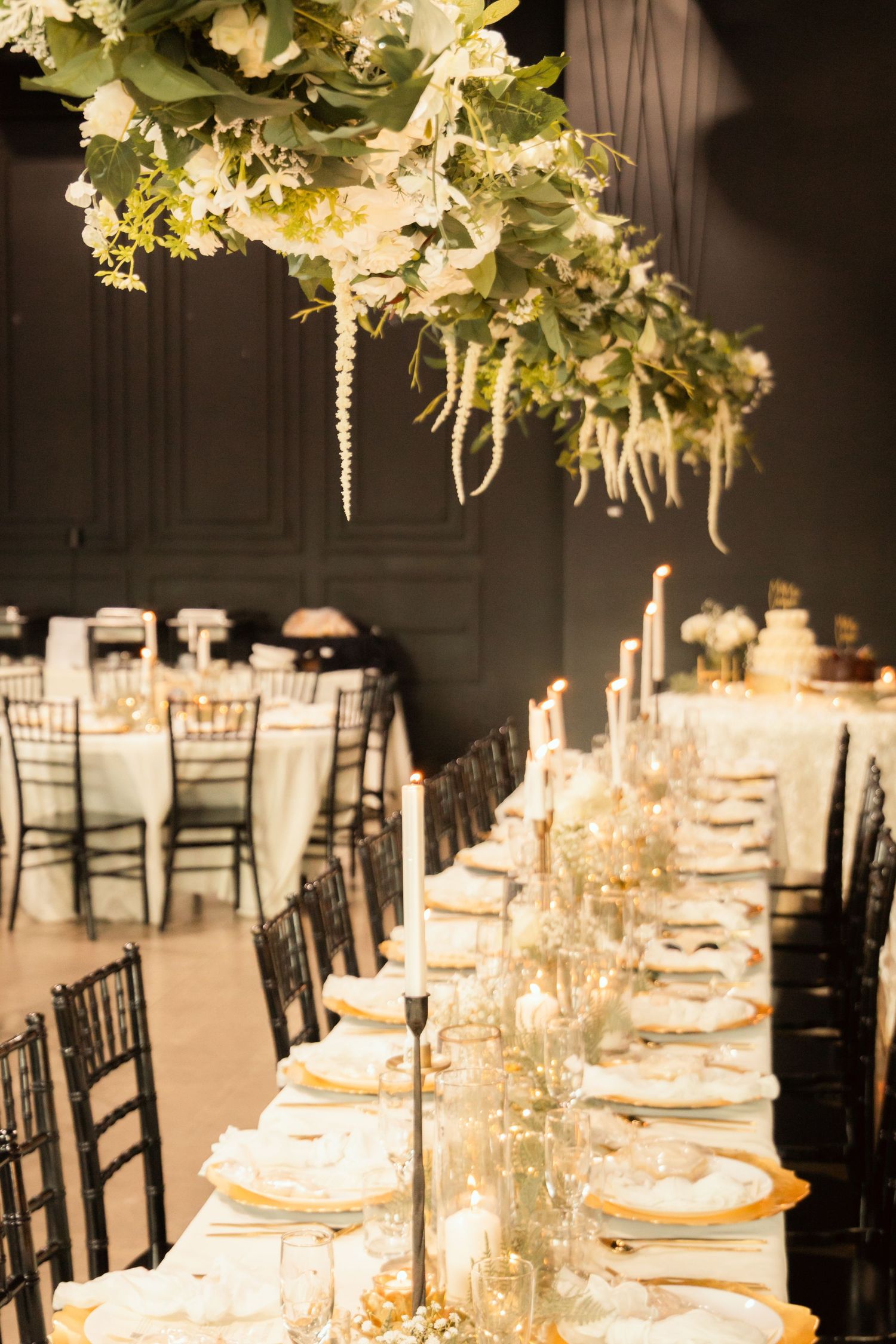 head table at a wedding with a beautiful hanging floral piece and candles