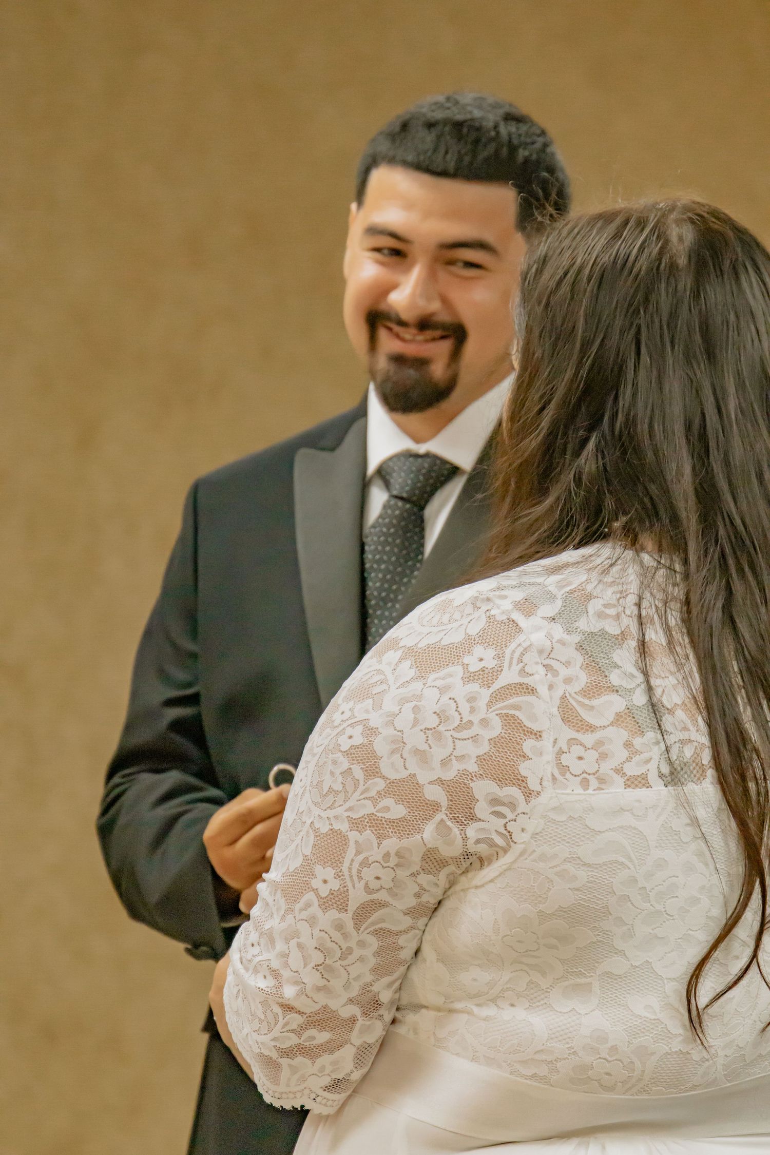 Groom lovingly looking at his bride during their wedding ceremony.