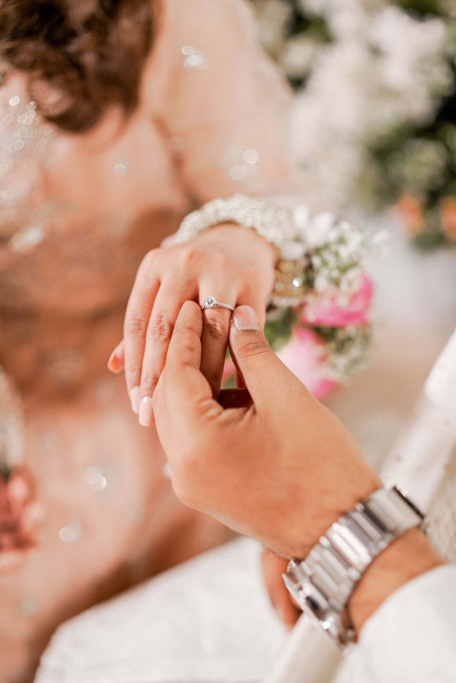 Close-up shots of hands displaying engagement rings with delicate floral details in background.