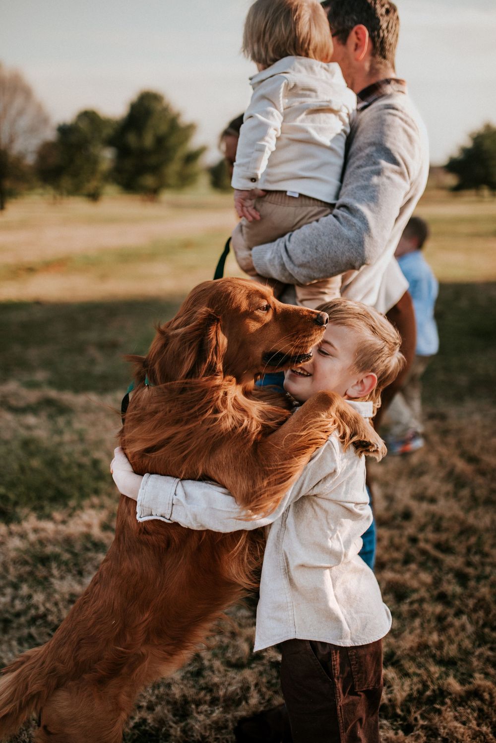 Family session with the dog hugging the son in a field in Sango, Tennessee.