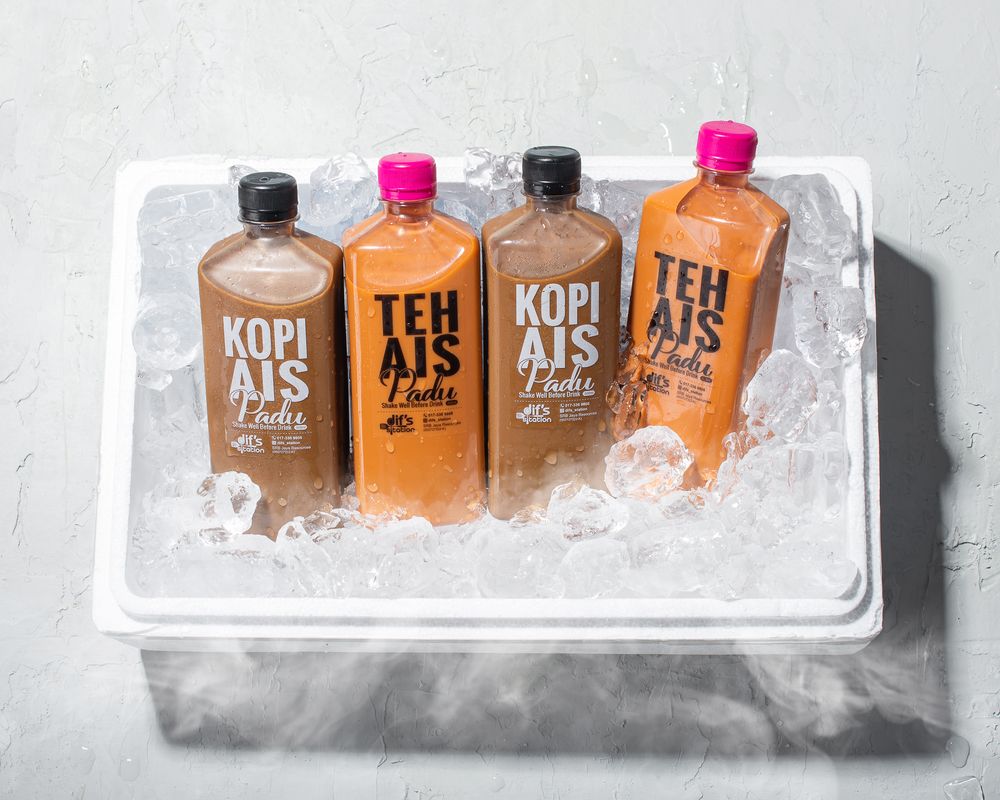 Coffee drink bottles in brown and orange tones chilling in ice.