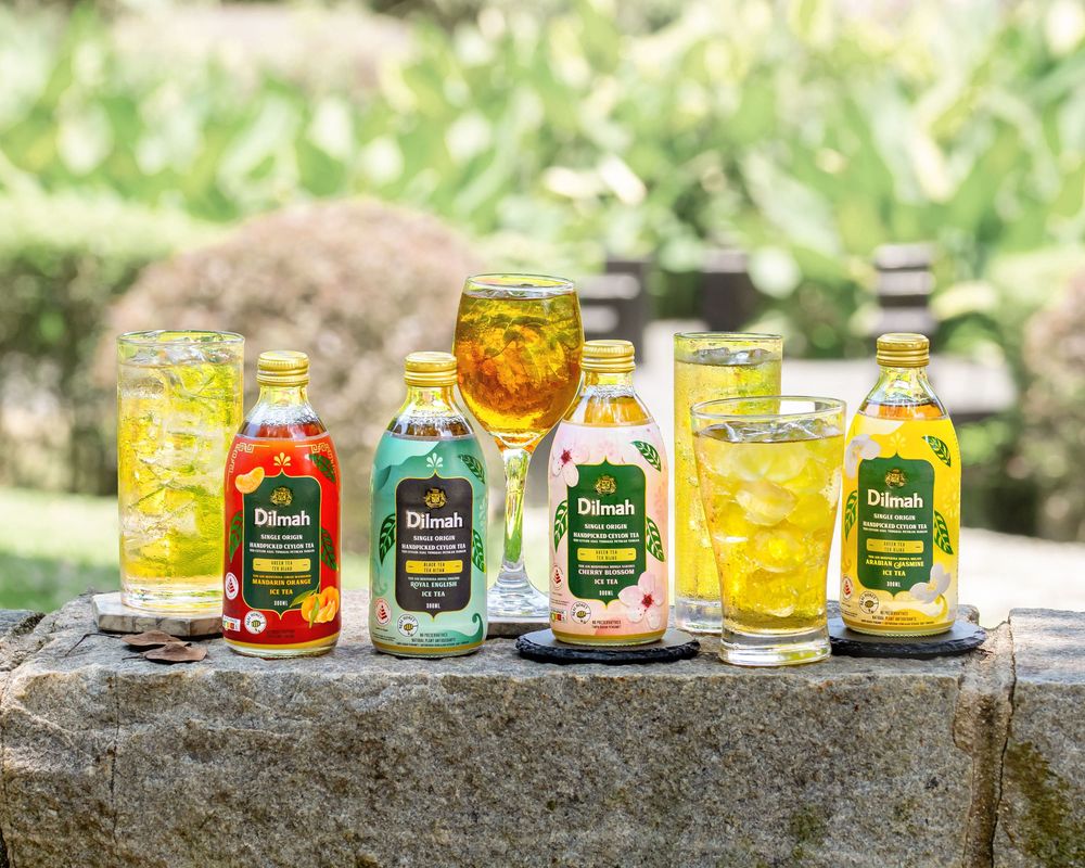 Colorful collection of honey jars displayed on a rustic stone wall outdoors.