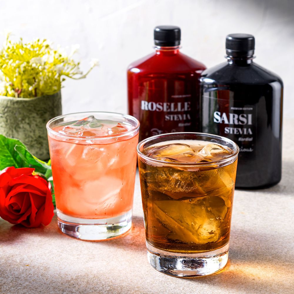 Collection of cocktails and spirits with roses displayed on a light colored surface.