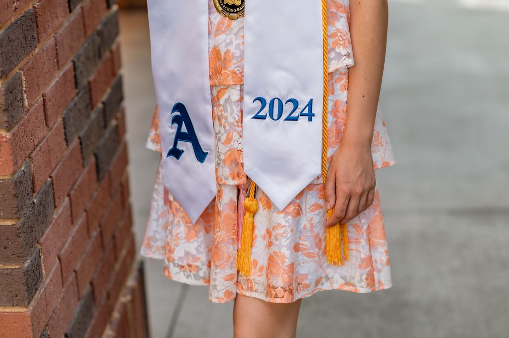 Close-up of graduation stole showing class of 2024 and letter A emblem.