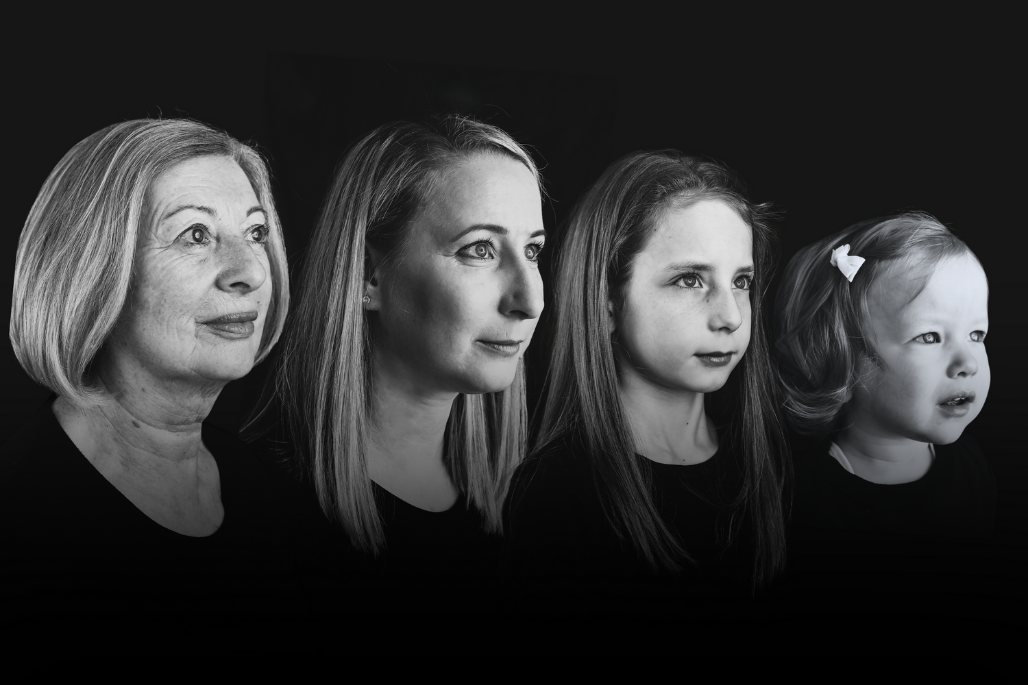 Black and white side profile portrait of four generations of women arranged in a row.