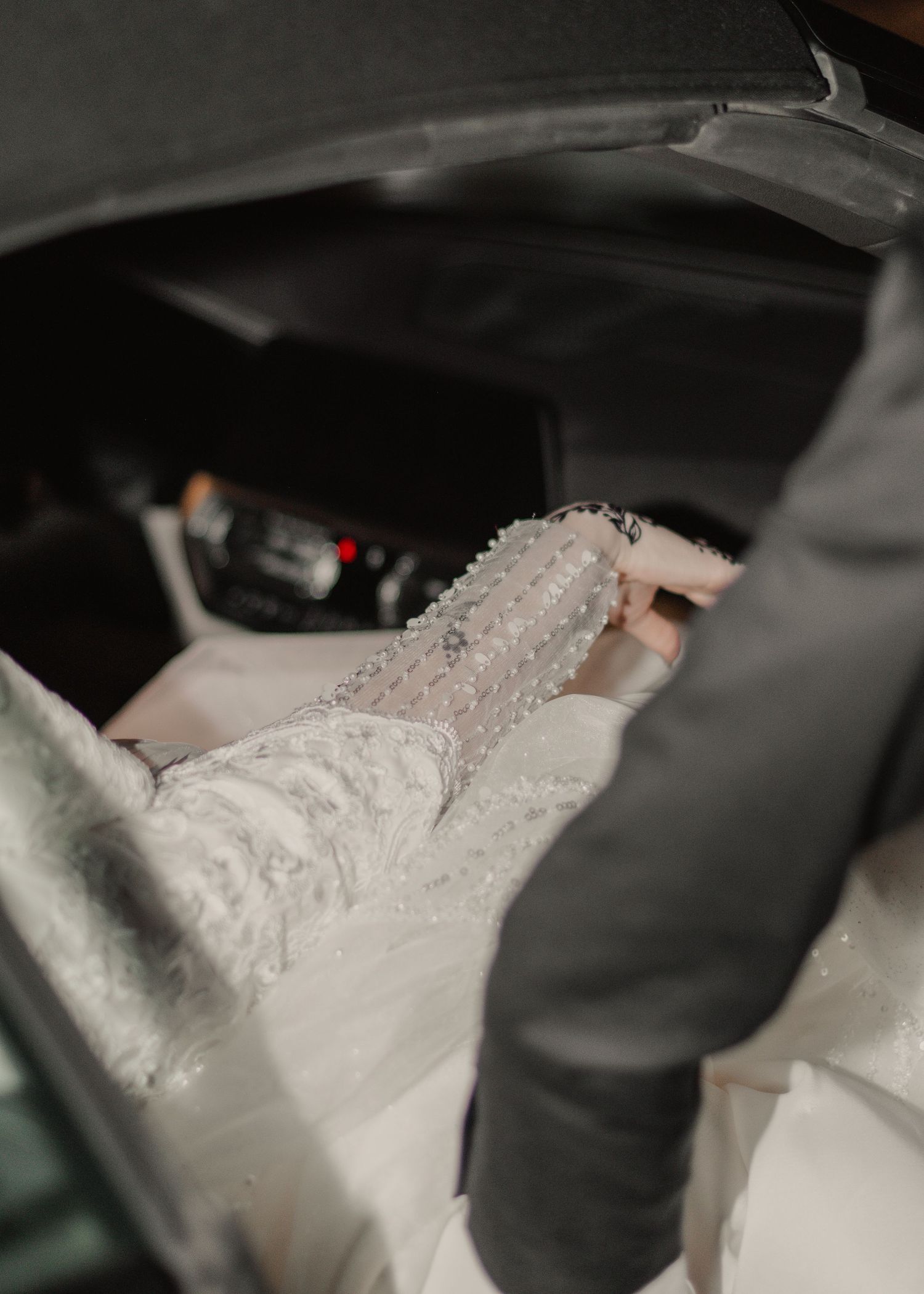 Hijabi-friendly image of a bride's hand adorned with intricate henna, reaching towards the groom's hand.