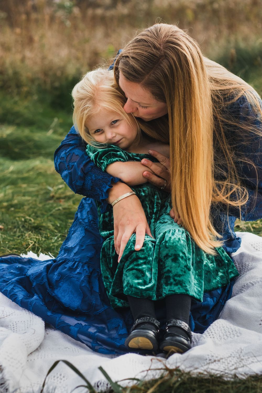 Mother giving her daughter a kiss on the cheek during a lifestyle family photography session in Farmington Hills, Michigan.