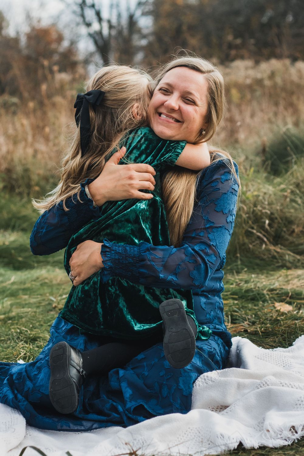 Mother and daughter hugging on a blanket during a lifestyle family photography session in Farmington Hills, Michigan.