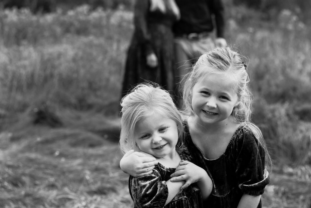 Sister's smiling during lifestyle family photo session - Michigan family photographer in Farmington Hills, Michigan.