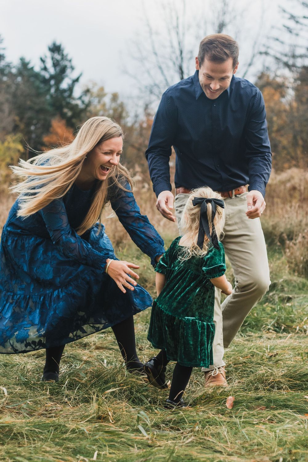 Little girl running to parents during a lifestyle family photography session in Farmington Hills, Michigan.
