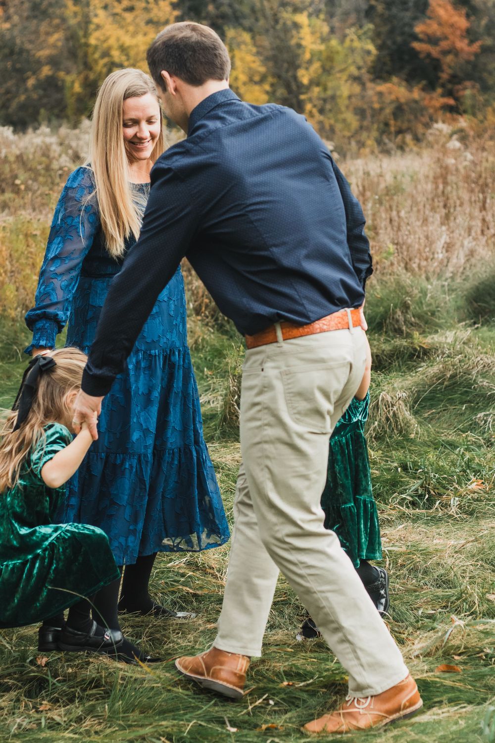 Family playing ring-around-the-rosy during a lifestyle family photography session in Farmington Hills, Michigan.