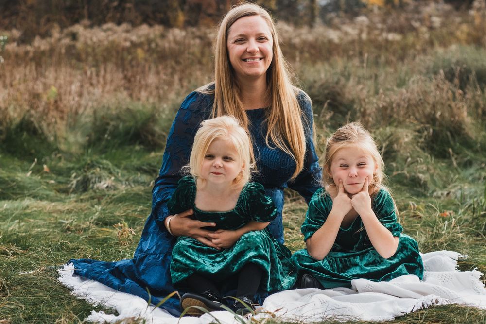 Mother sitting with her two daughter making silly faces during a lifestyle family photography session in Farmington Hills, Michigan.