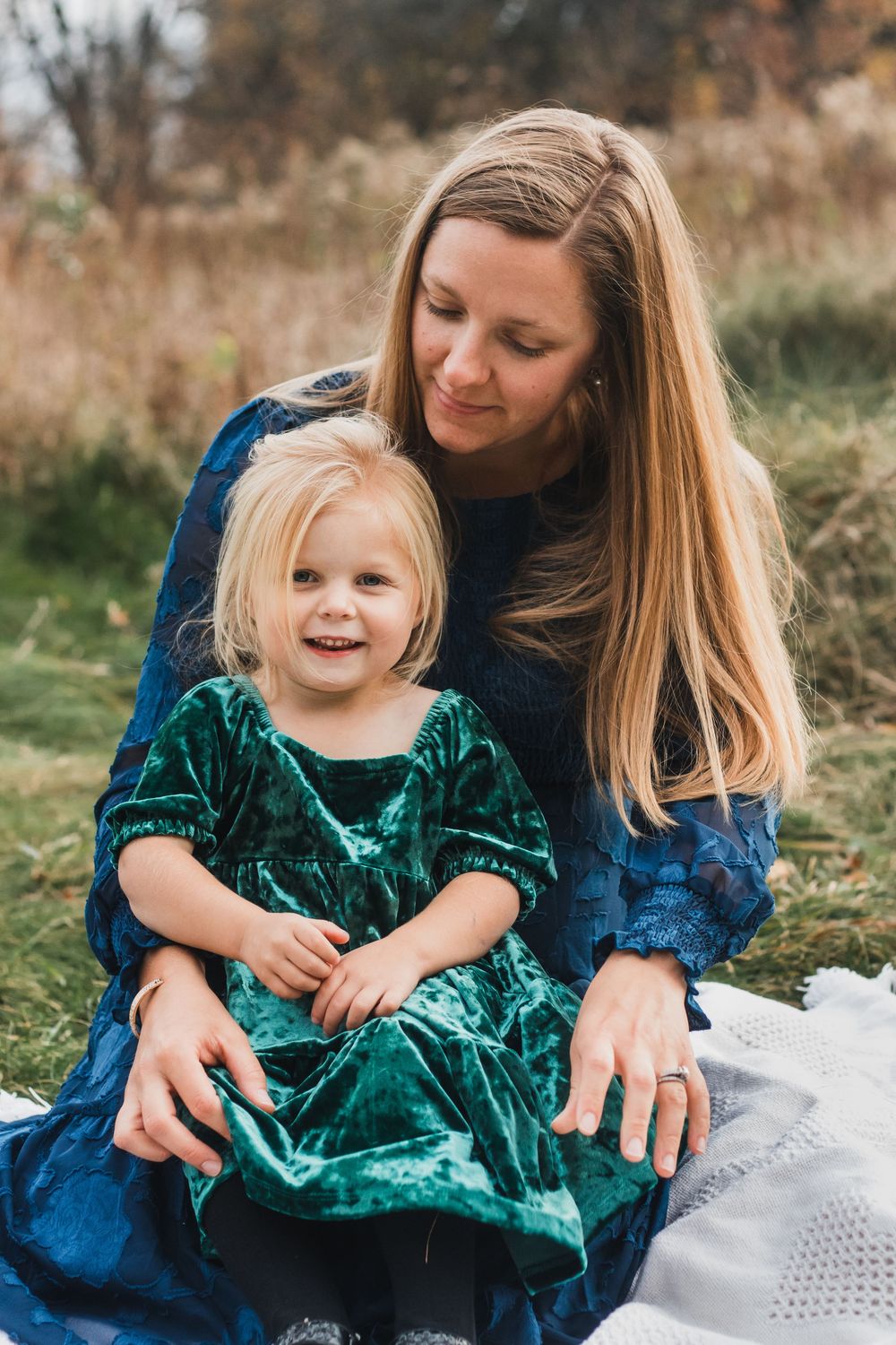 Mother and daughter sitting on a blanket during a golden hour lifestyle family photography session in Farmington Hills, Michigan.