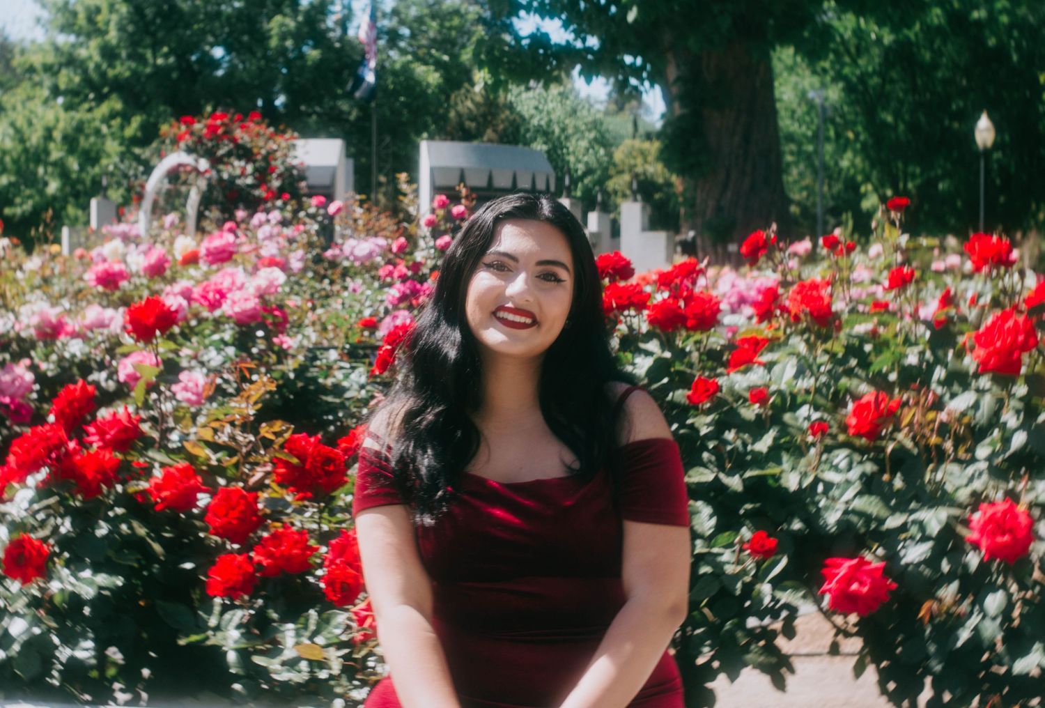 Portrait in a beautiful garden with blooming red roses.