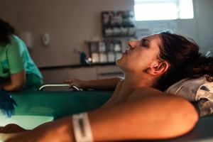 Medical staff provide care during a hospital procedure under bright lighting.