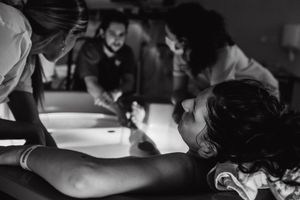 Healthcare team collaborates during a medical procedure in dimly lit environment.