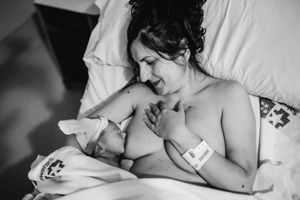 Intimate skin-to-skin contact moment in black and white photography.