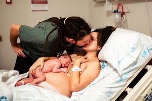 Gentle nurturing moment in hospital room with warm ambient lighting.