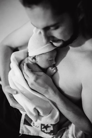 Intimate black and white portrait of newborn bonding moment.