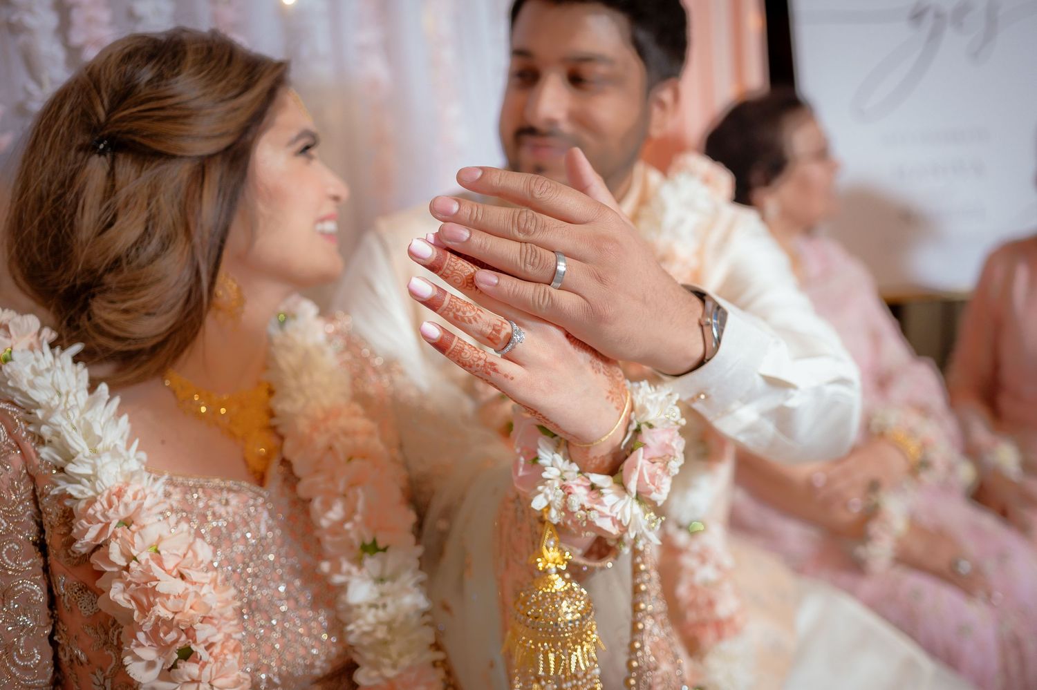 Close up of hands displaying delicate engagement ring.