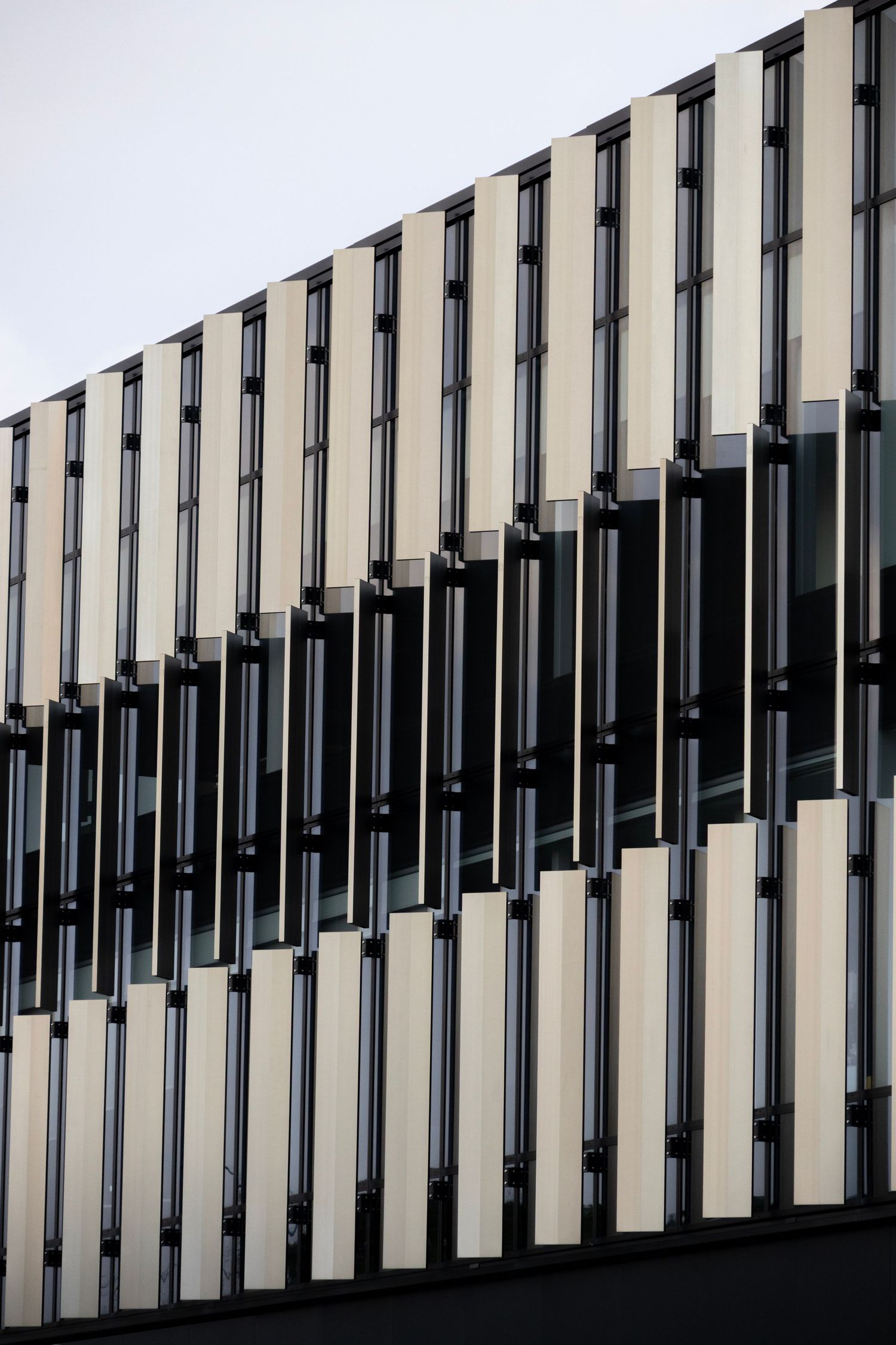 Vertical fin-style panels reflecting daylight on a modern building facade.