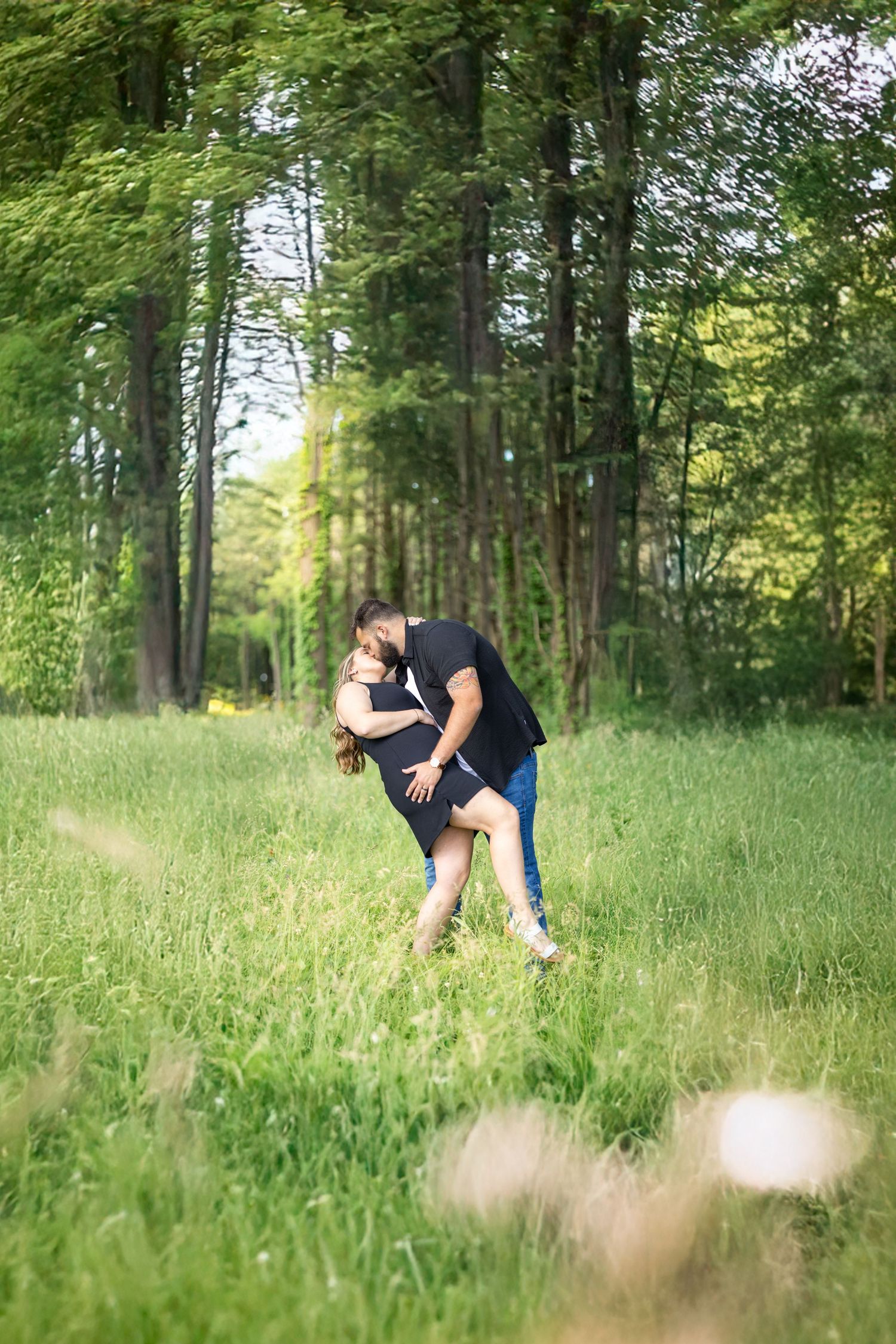 Springfield, IL photographer captures a couple dipping for a kiss amongst tall grass during a session in Central, IL