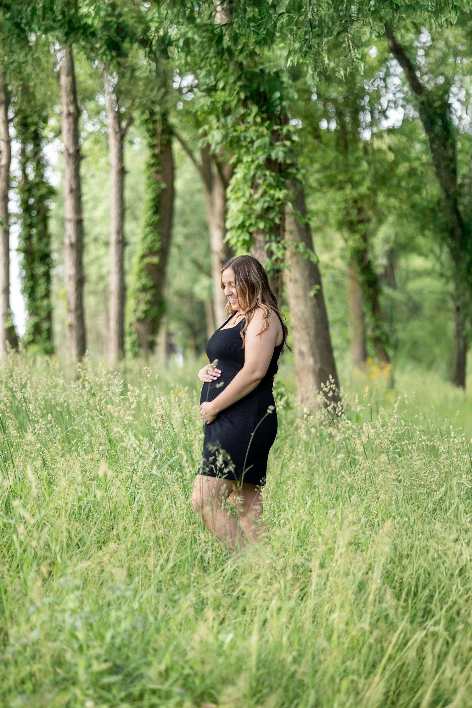 Springfield, IL photographer captures an expectant mother smiling down on her baby during a maternity session in Central, IL