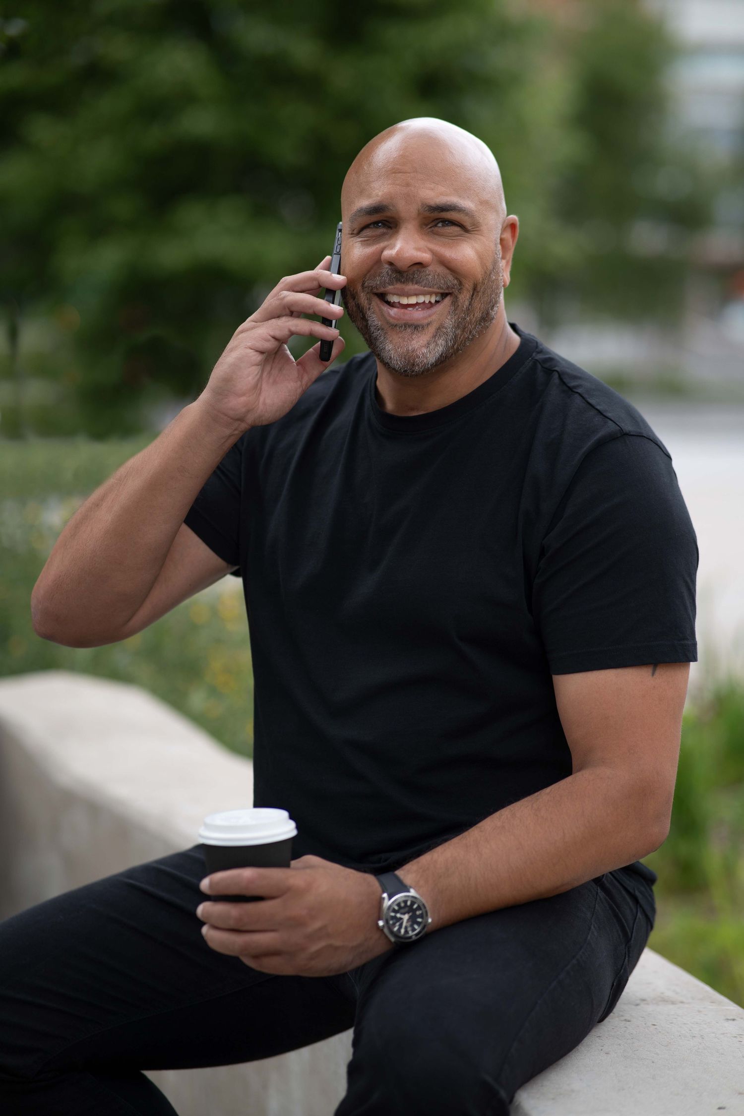 Steve Currie personal branding photographer takes a minute to have a coffee and a phone call, sat on a wall in Southampton
