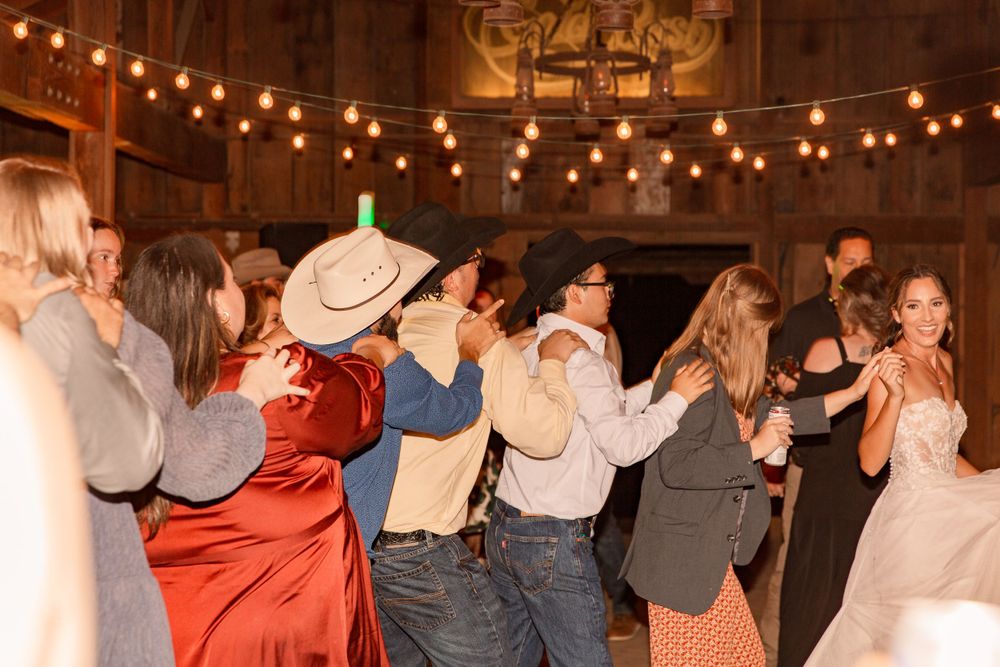 Couples dancing in formation at a country western themed wedding reception.