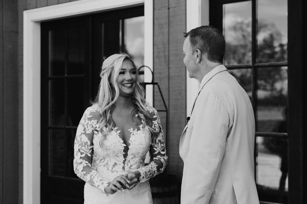 A candid moment captured between two people sharing a joyful conversation during a wedding event.