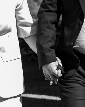 Black and white close-up photo of two people holding hands.