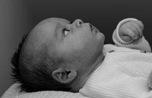 Side profile of sleeping newborn in black and white photography.