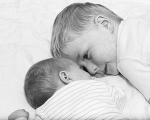 Intimate black and white series showing gentle sleeping moments on white bedding.