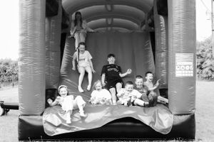 Children playing and jumping inside an inflatable bounce house in black and white photography.