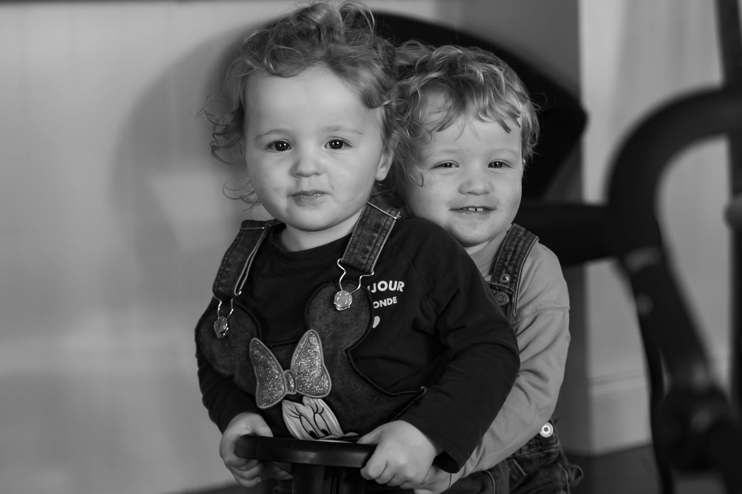 Series of black and white candid shots of toddlers playing together indoors.