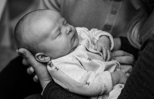 Black and white close-up photos capturing intimate moments with a sleeping newborn.