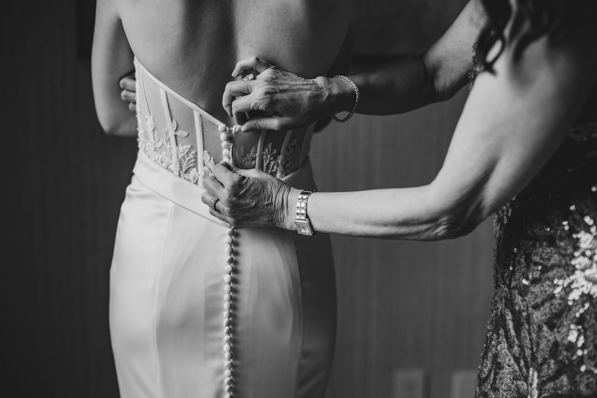 A close-up detail of a wedding dress showing delicate button closures down the back.