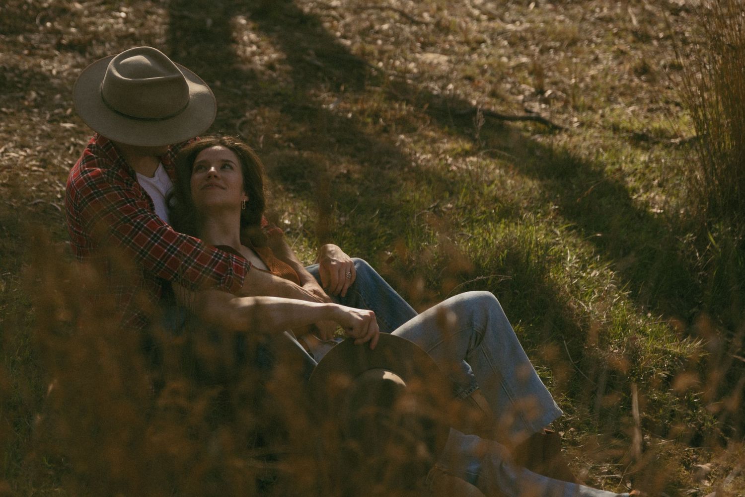 A husband and wife laying by the creek with cinematic tones.