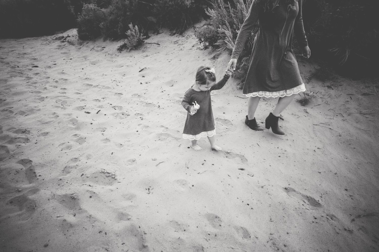 Two little girls walk with footprints in the sand in Wyoming