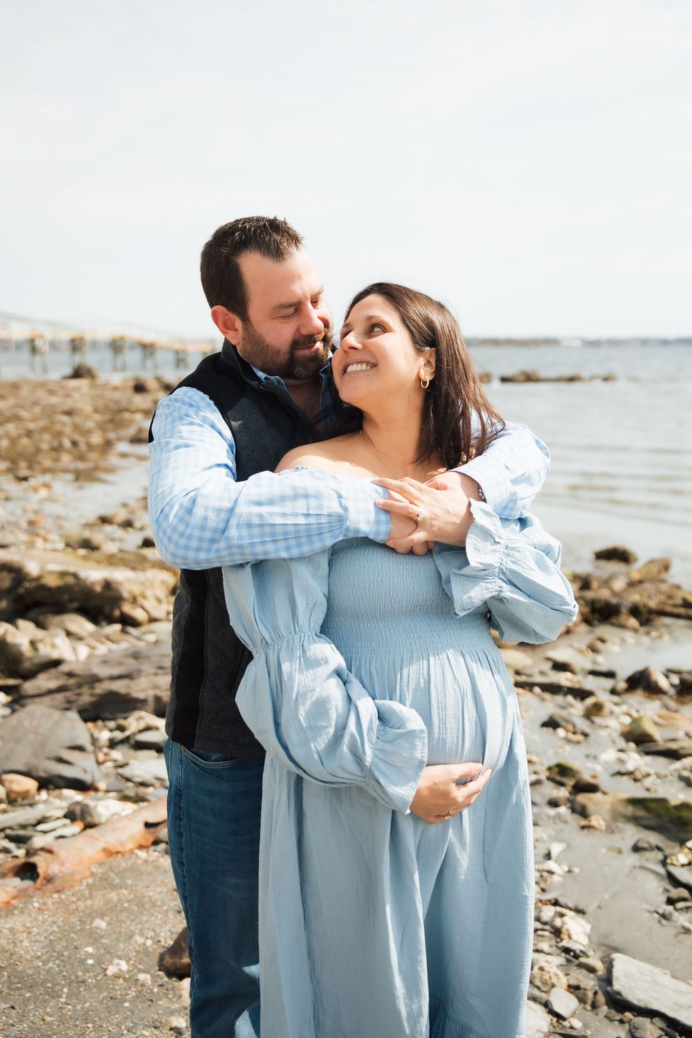 Couple embracing on rocky beach, pregnant woman.  maternity photoshoot, Beavertail Jamestown RI