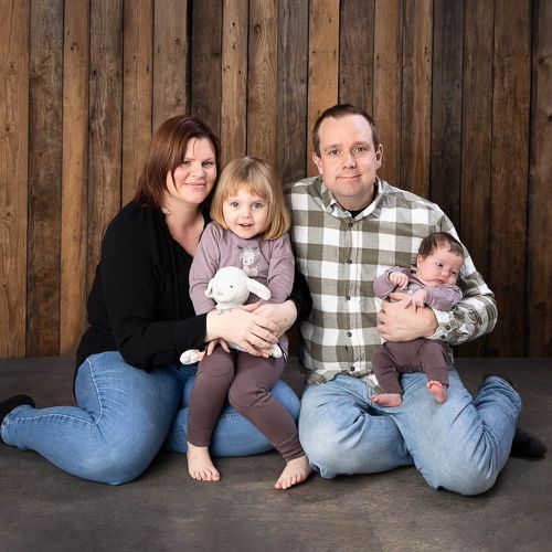 Family members sit in casual poses against a rustic wooden wall backdrop showing a creative photo sequence.