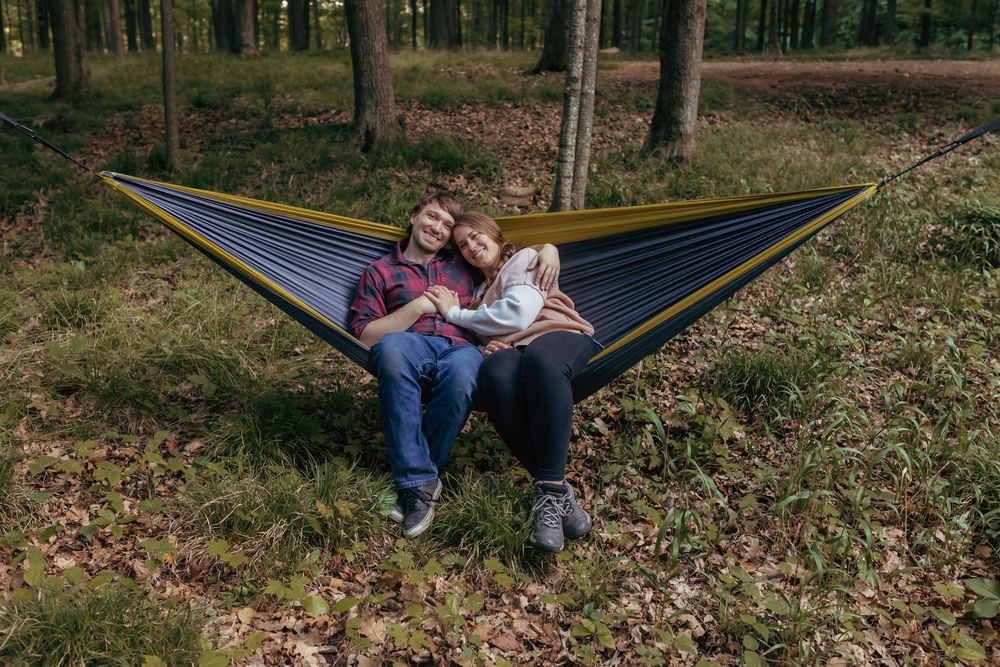 Engaged couple cuddling on a hammock during their outdoor engagement session in Northern Wisconsin.