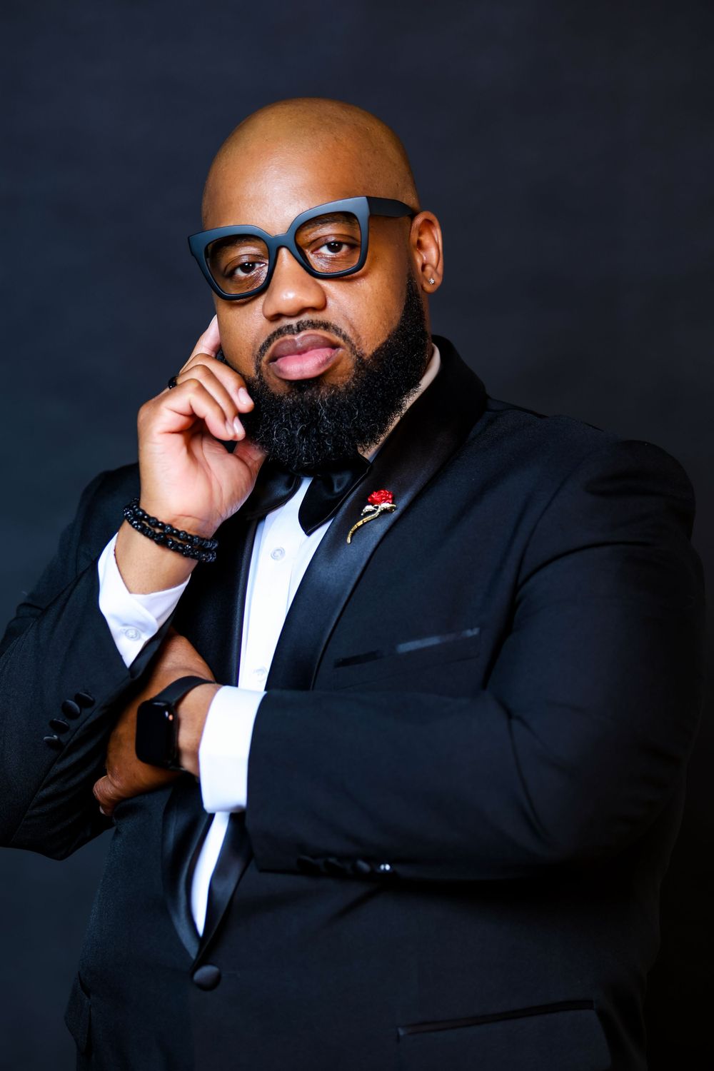 Business portrait series showing person in black suit and glasses with various poses.