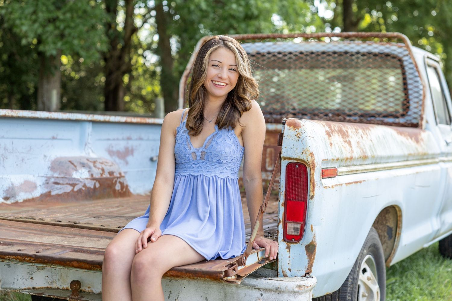 A high school senior girl poses in a truck in her Four Oaks NC Senior Photos.