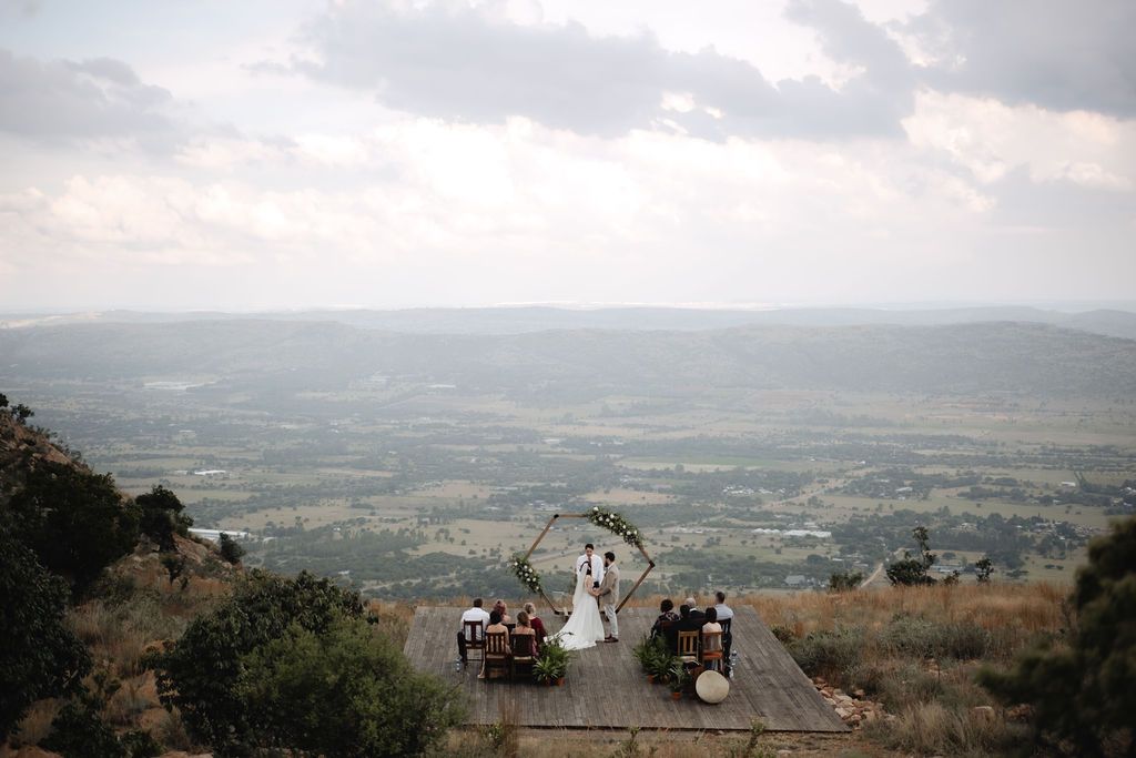 intimate wedding with Pretoria in background and beautiful hexagon arch with flowers, taken by Wouter Kleynhans Photography at Intiem